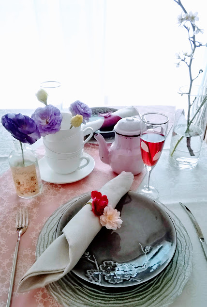 桜の枝を飾り、ピンクを基調にしたお花見のテーブル。造花や桜の花びらのシールなど100円ショップの雑貨を活用したプチプラのテーブルコーディネート例です。
