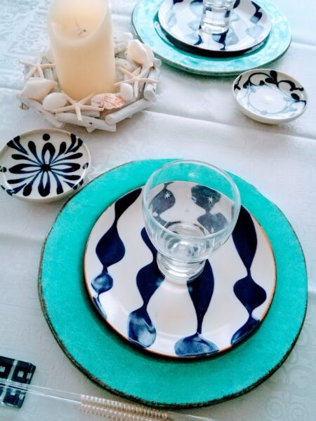 やちむんを使ったブルーでまとめた夏のテーブルコーディネート。貝殻のリースをキャンドルホルダーにして、センターピースに。